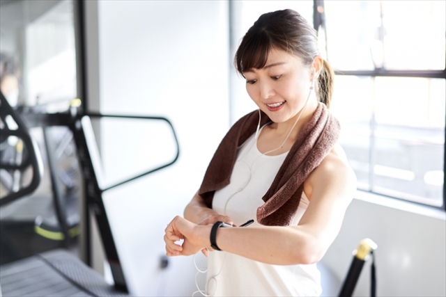 時間を見ながらトレーニングする女性写真